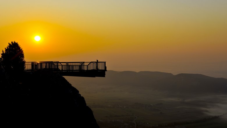 Skywalk, © Robert Herbst/NÖ Naturparke Skywalk bei Sonnenuntergang mit Blick auf eine Landschaft und Berge im Hintergrund.