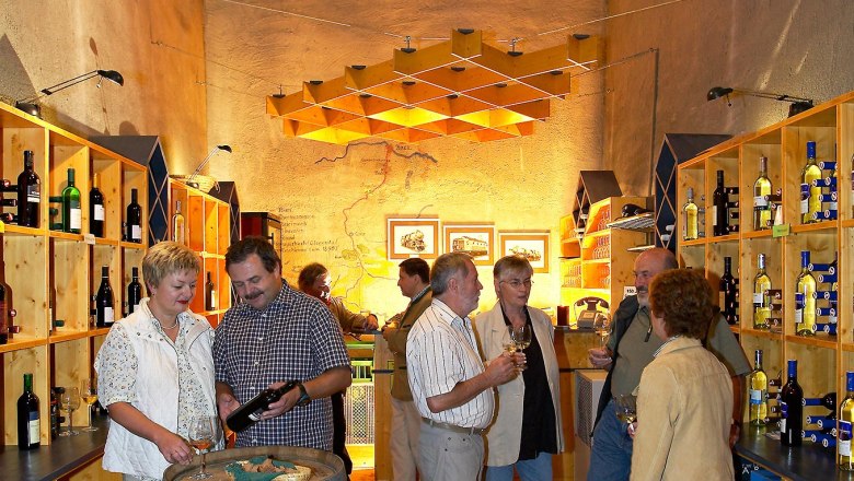 Menschen in einem Weinkeller bei einer Weinprobe.