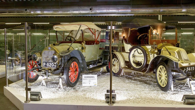 Historische Autos im Automobilmuseum hinter Glas ausgestellt.