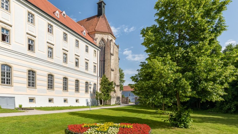 Stift Neukloster mit Garten und Blumenbeet im Vordergrund.
